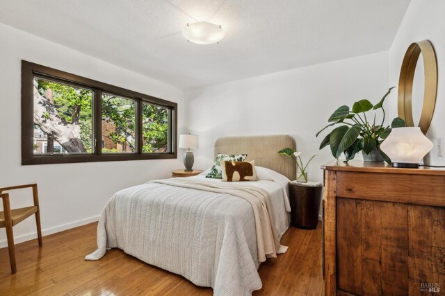 bedroom with baseboards and wood finished floors