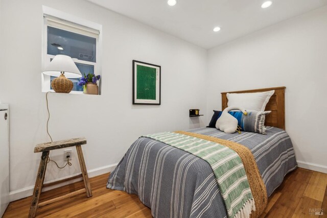 bedroom with light wood-style floors, baseboards, and recessed lighting
