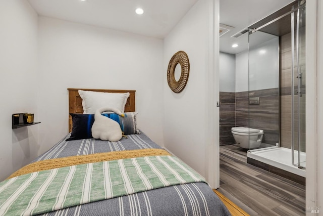 bedroom featuring recessed lighting, visible vents, wood finished floors, and tile walls
