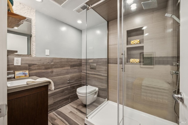 full bathroom with toilet, tile walls, visible vents, and a stall shower