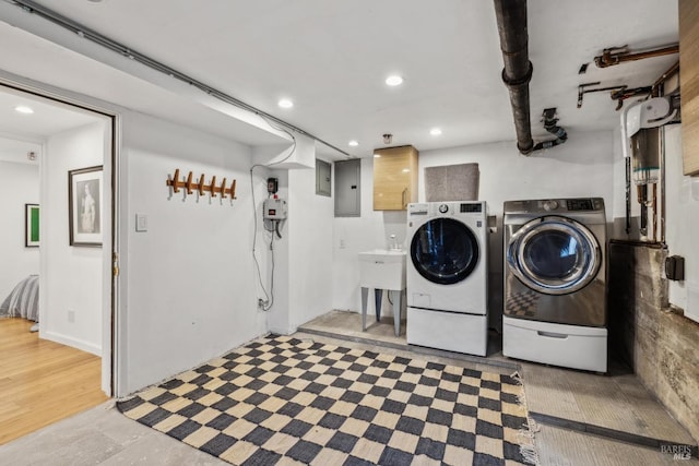 laundry area featuring electric panel, laundry area, washing machine and clothes dryer, light wood-style floors, and recessed lighting