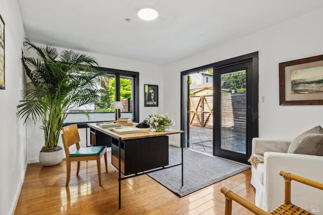 office space featuring baseboards and light wood-type flooring