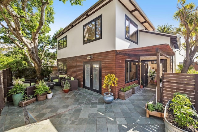 back of property with a patio, fence, french doors, and stucco siding