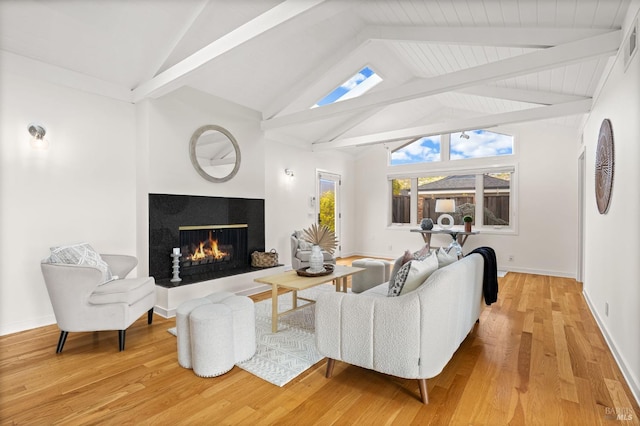 13 Leeward Rd, Belvedere, CA 94920 - living room featuring baseboards, wood finished floors, lofted ceiling with beams, and a lit fireplace
