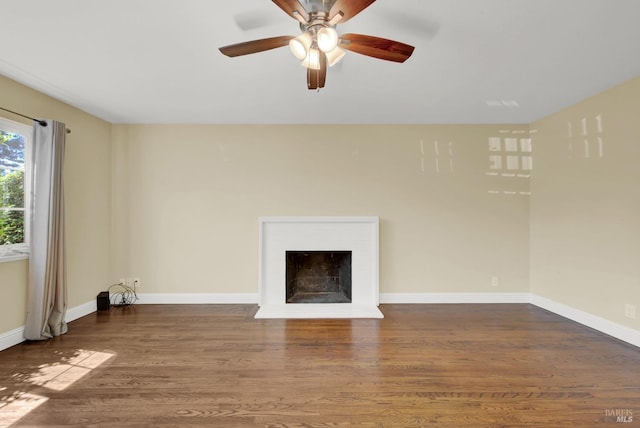 unfurnished living room featuring baseboards, a ceiling fan, wood finished floors, and a fireplace with flush hearth