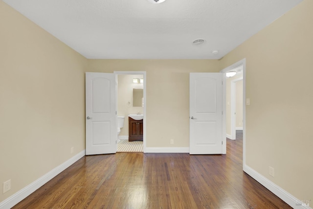unfurnished bedroom with baseboards and dark wood finished floors