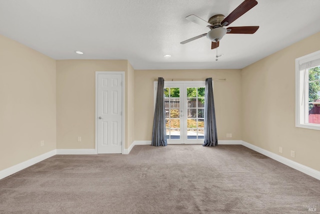 spare room featuring a healthy amount of sunlight, ceiling fan, baseboards, and carpet floors