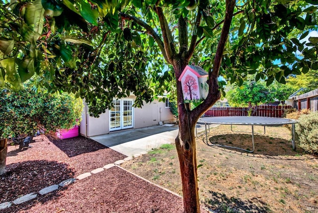 view of yard with a patio, a trampoline, and fence private yard