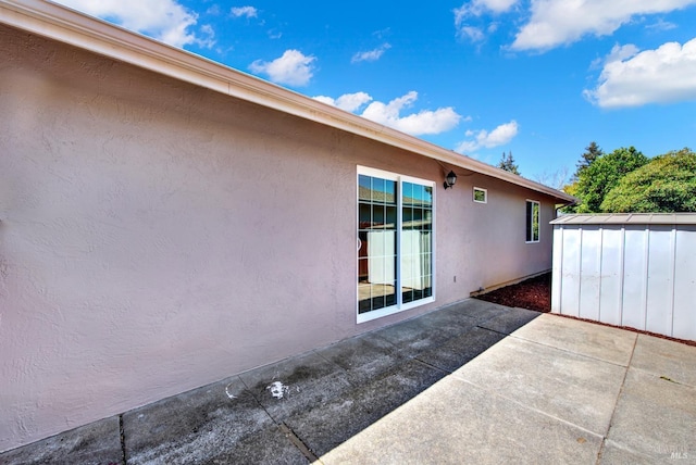 view of patio / terrace featuring a storage shed and an outbuilding