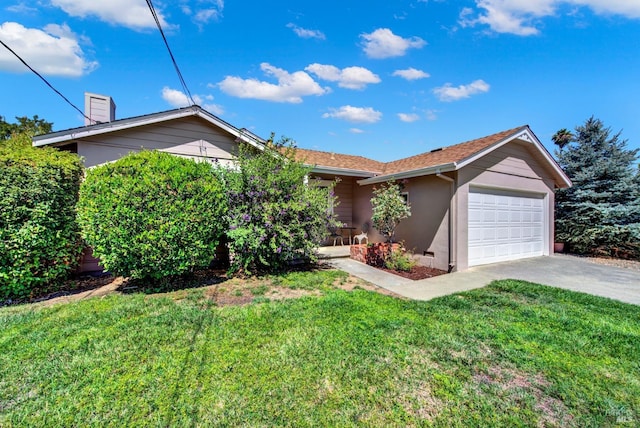 view of front of property with a front yard, a garage, a chimney, stucco siding, and driveway