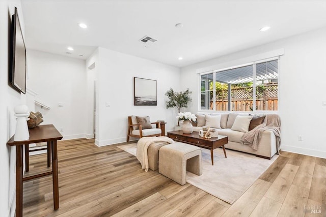 living room with recessed lighting, light wood finished floors, visible vents, and baseboards