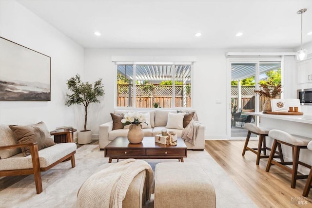 living room featuring light wood-style flooring, recessed lighting, and plenty of natural light