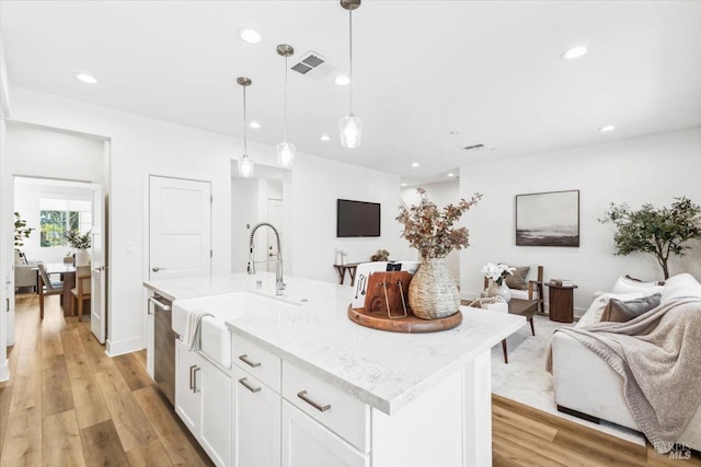 kitchen with a sink, visible vents, open floor plan, and dishwasher