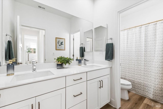full bath featuring a sink, visible vents, toilet, and wood finished floors