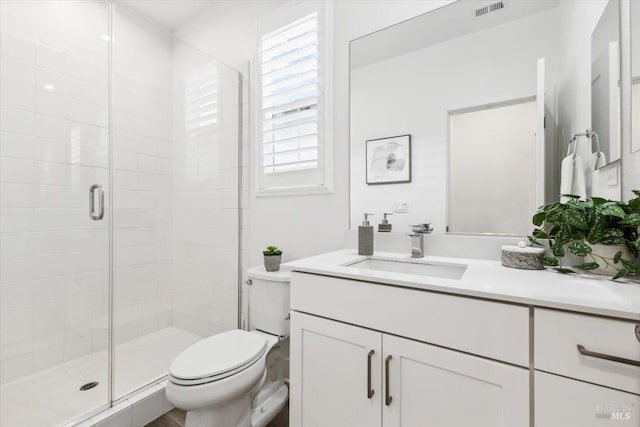 full bathroom with visible vents, toilet, a stall shower, and vanity