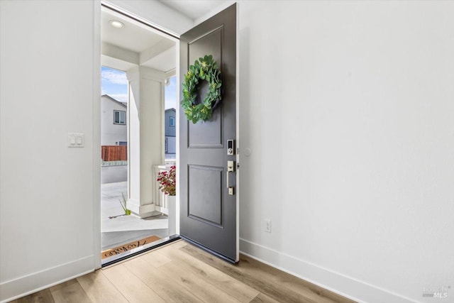 foyer entrance featuring light wood finished floors and baseboards