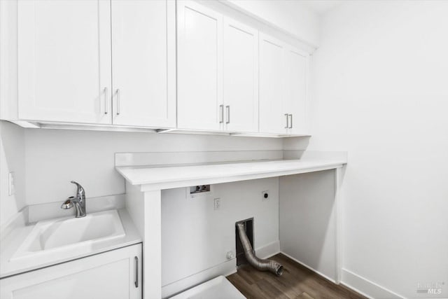 clothes washing area featuring hookup for an electric dryer, a sink, dark wood finished floors, and cabinet space