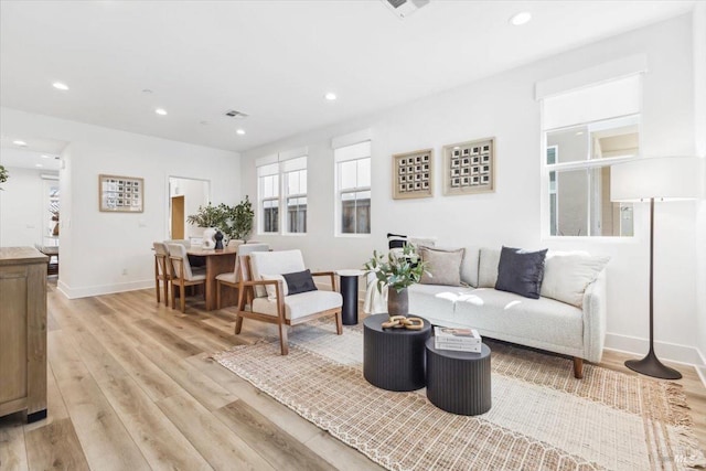 living area with visible vents, light wood-type flooring, and recessed lighting