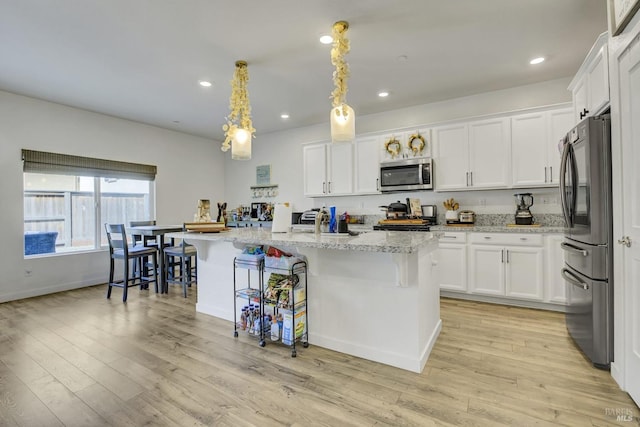 1090 Swarthmore Ct, Dixon, CA 95620 - kitchen featuring stainless steel appliances, white cabinetry, recessed lighting, and a kitchen bar