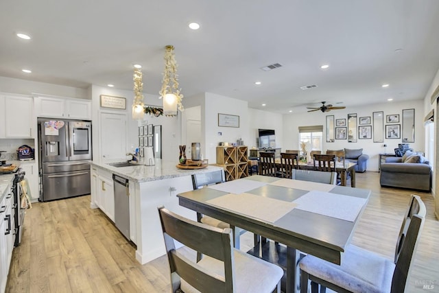 1090 Swarthmore Ct, Dixon, CA 95620 - kitchen with appliances with stainless steel finishes, a ceiling fan, white cabinets, a sink, and a center island with sink