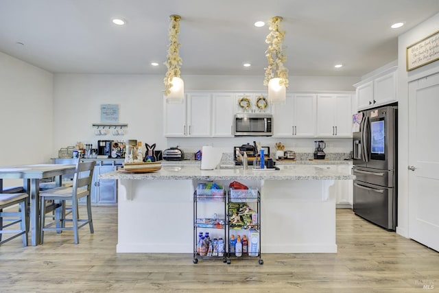1090 Swarthmore Ct, Dixon, CA 95620 - kitchen with appliances with stainless steel finishes, white cabinetry, recessed lighting, a kitchen breakfast bar, and a kitchen island with sink