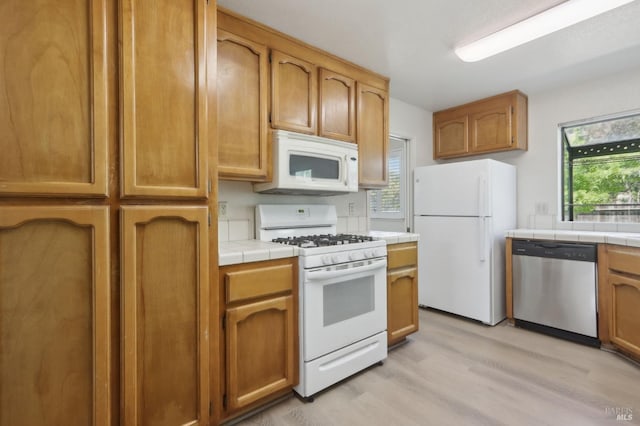 220 Sandy Neck Way, Vallejo, CA 94591 - kitchen with white appliances, tile counters, light wood-style floors, and brown cabinetry