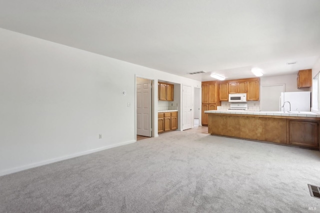 220 Sandy Neck Way, Vallejo, CA 94591 - kitchen with white appliances, light carpet, tile counters, a peninsula, and baseboards