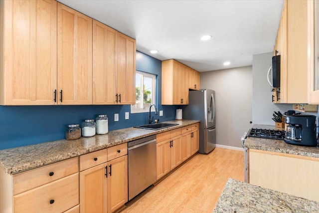kitchen featuring a sink, light wood-type flooring, light brown cabinetry, and stainless steel appliances