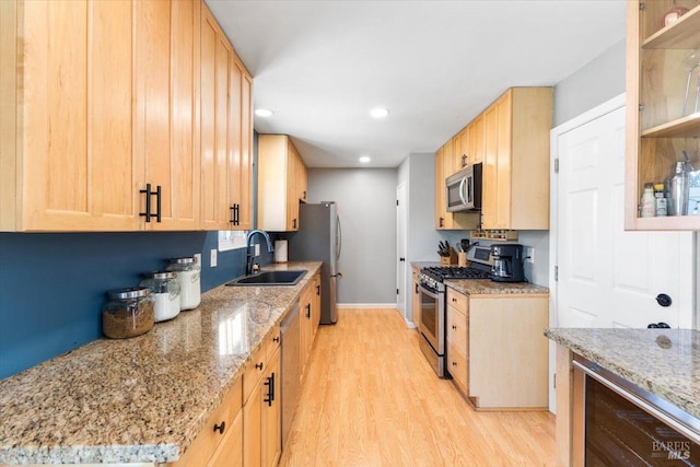 kitchen featuring light brown cabinets, wine cooler, appliances with stainless steel finishes, and a sink