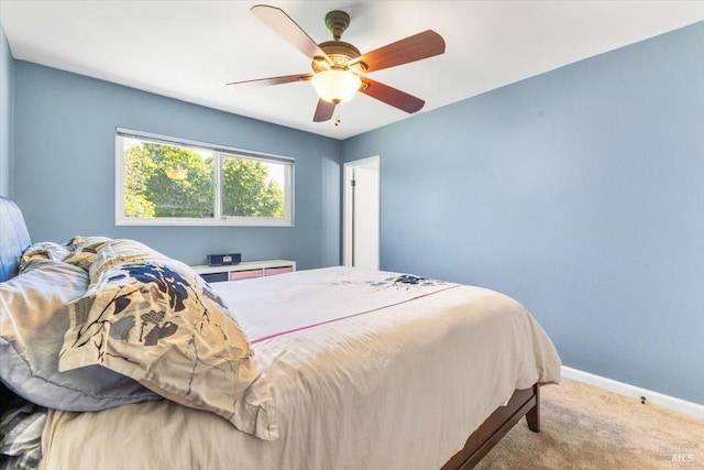 carpeted bedroom featuring baseboards and a ceiling fan