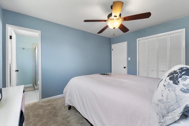 bedroom featuring light carpet, a closet, baseboards, and a ceiling fan
