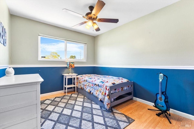bedroom featuring ceiling fan, baseboards, and wood finished floors