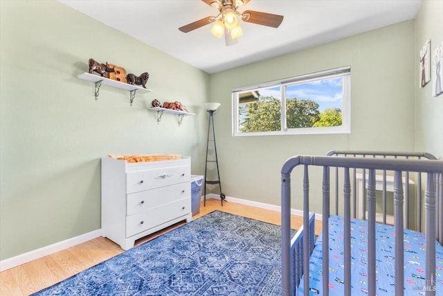 bedroom featuring baseboards, a ceiling fan, and wood finished floors