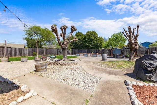 view of yard with an outdoor fire pit, a fenced backyard, and a patio
