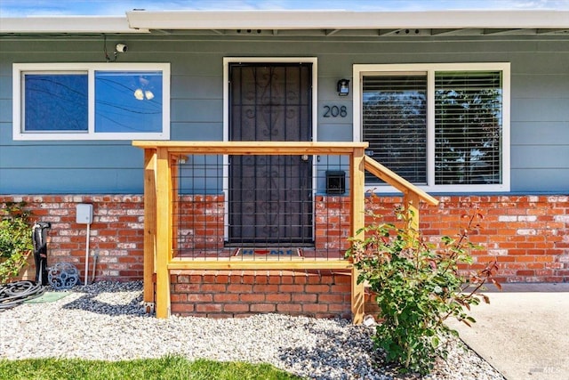 property entrance with brick siding and covered porch