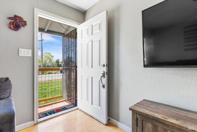 foyer featuring baseboards and light wood-style floors