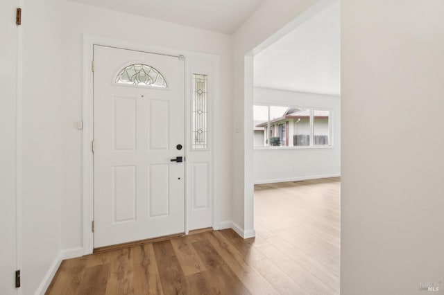 entryway featuring baseboards and wood finished floors
