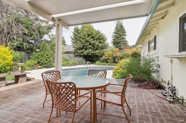 view of patio with a fenced in pool, outdoor dining area, and a fenced backyard