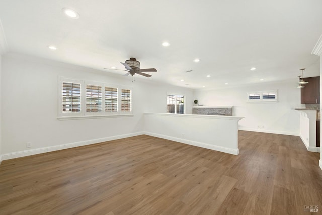 unfurnished living room featuring a ceiling fan, visible vents, recessed lighting, wood finished floors, and baseboards