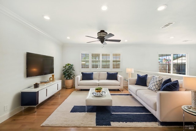 living area with ornamental molding, recessed lighting, a ceiling fan, visible vents, and wood finished floors