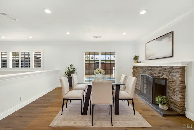 dining area with a wealth of natural light, visible vents, and wood finished floors