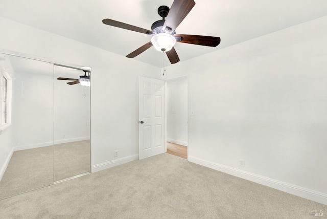 unfurnished bedroom with a closet, baseboards, carpet flooring, and ceiling fan