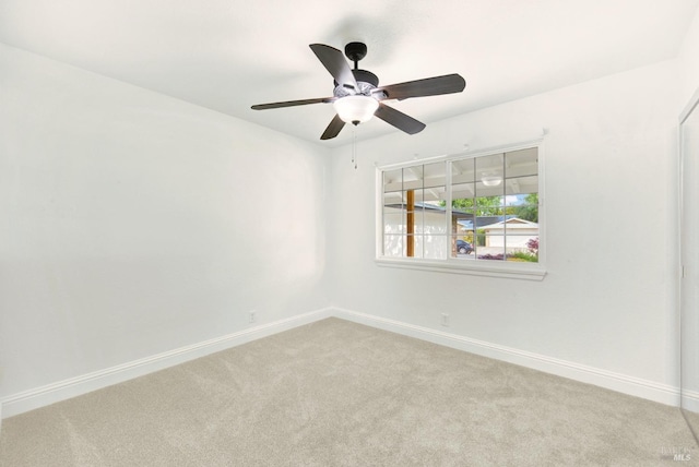 spare room with light carpet, baseboards, and ceiling fan