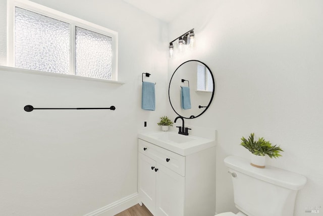 bathroom with vanity, baseboards, toilet, and wood finished floors