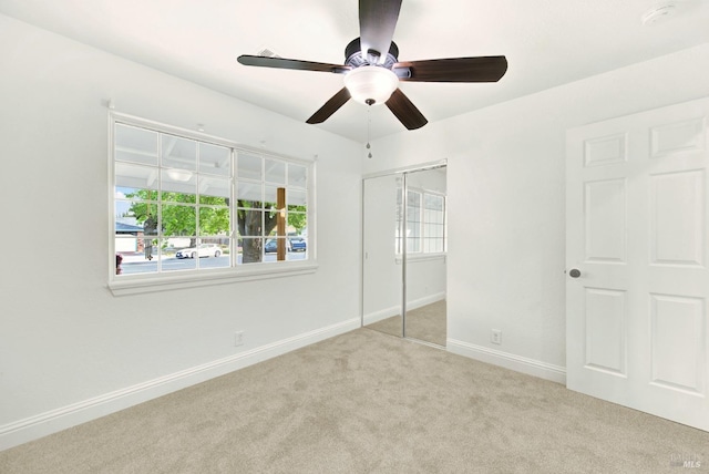 unfurnished bedroom featuring a closet, baseboards, a ceiling fan, and carpet