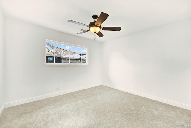 empty room featuring carpet floors, baseboards, ceiling fan, and visible vents