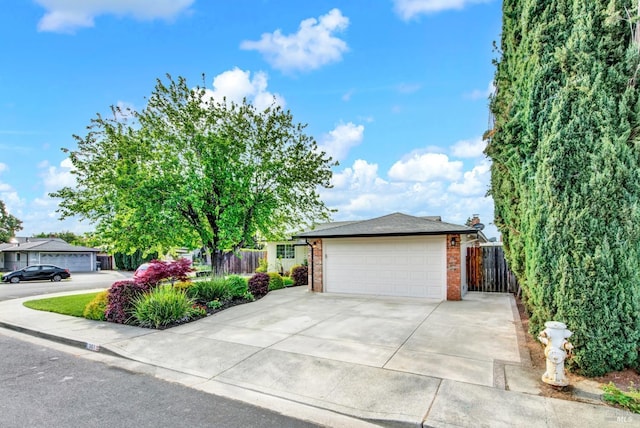 view of front of property with brick siding, driveway, fence, and a garage