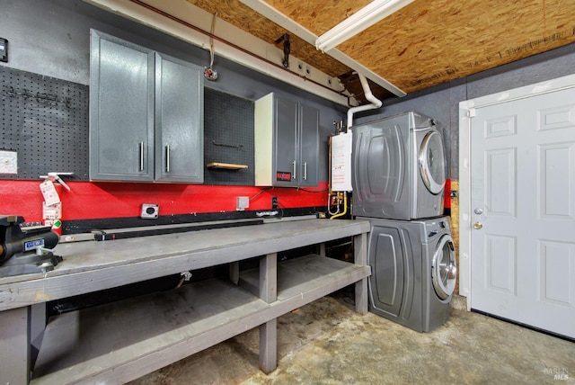 interior space featuring stacked washer and clothes dryer and a workshop area