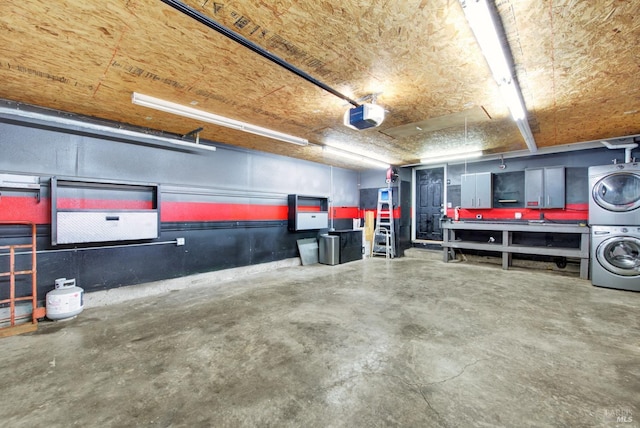 garage featuring stacked washing maching and dryer and a garage door opener