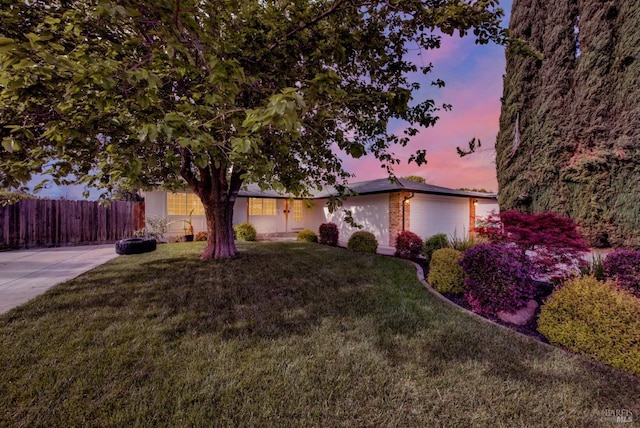 view of front of house with a yard and fence